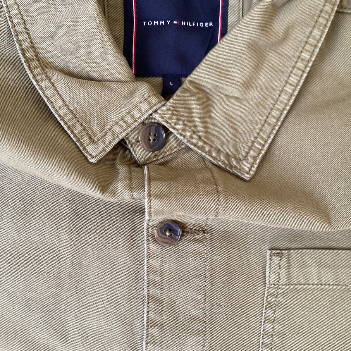 Tommy Hilfiger chore workwear jacket in dark fabric with front pockets and button closure, styled by BITAMBS.